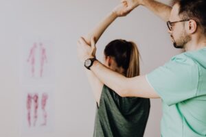 Physical therapist helping patient with shoulder rehabilitation exercises
