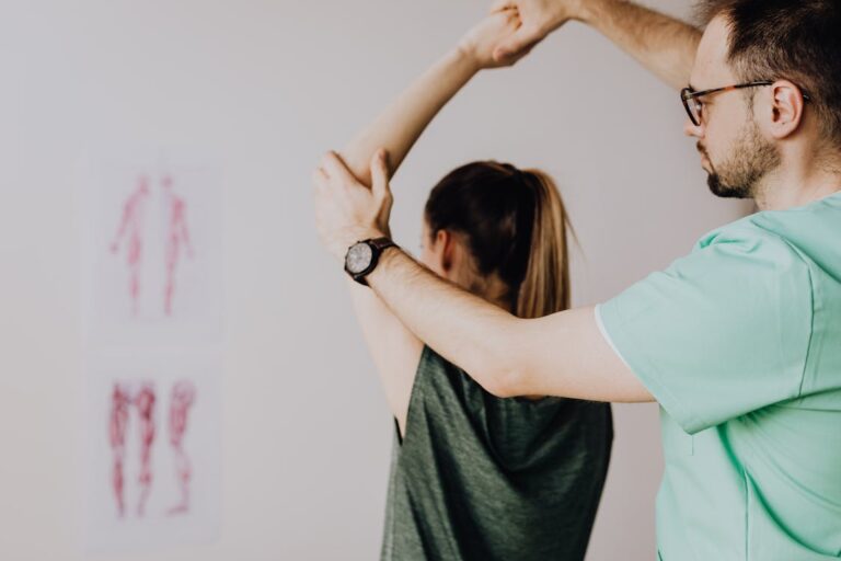 Physical therapist helping patient with shoulder rehabilitation exercises